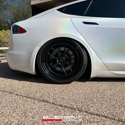Staggered 21 inch Variant Formula Satin Black Center, Gloss Black Outer, Blue Fasteners on a 2021 Tesla Model S